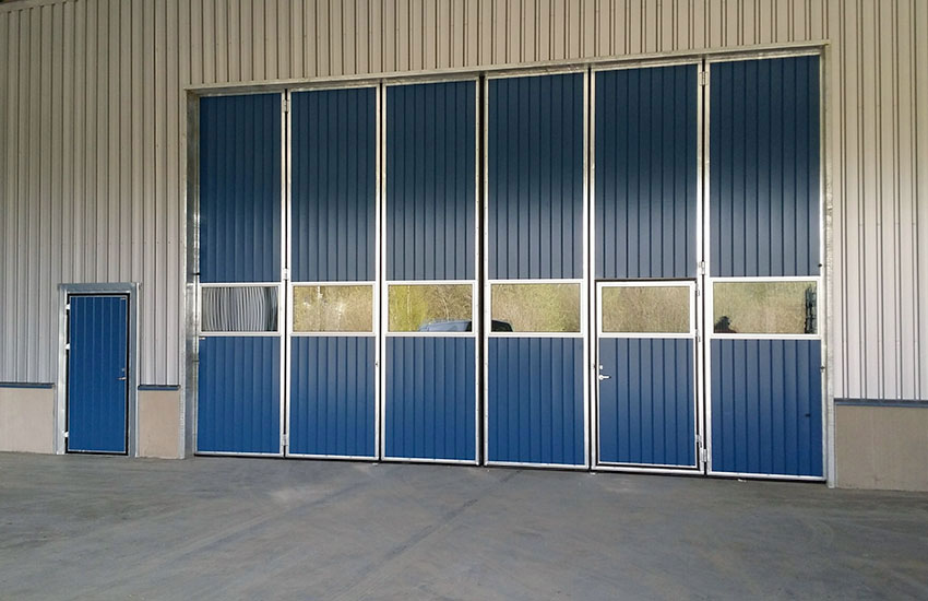 Blå vikportar med en rad glas och gångdörr vid sidan